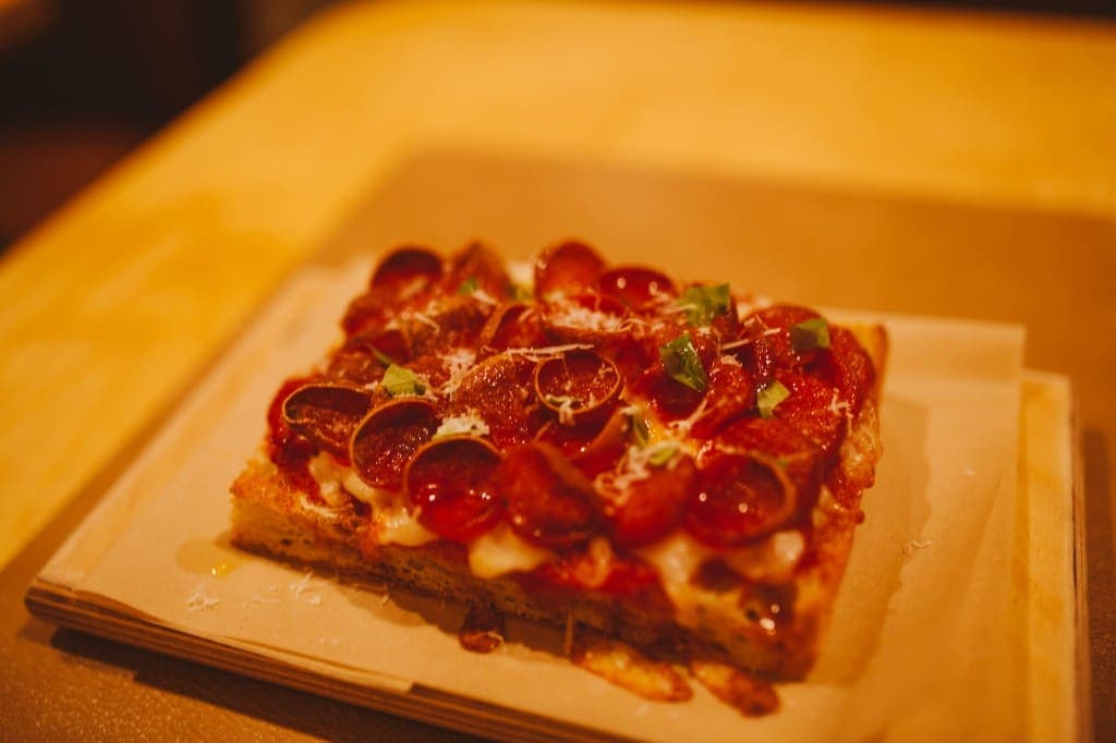 Pepperoni pizza slice on parchment at The Analogue Room in Solvang