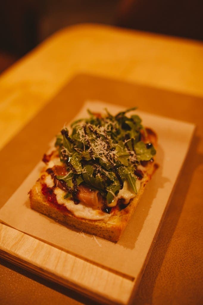 Prosciutto, arugula, and balsamic pizza slice at The Analogue Room in Solvang