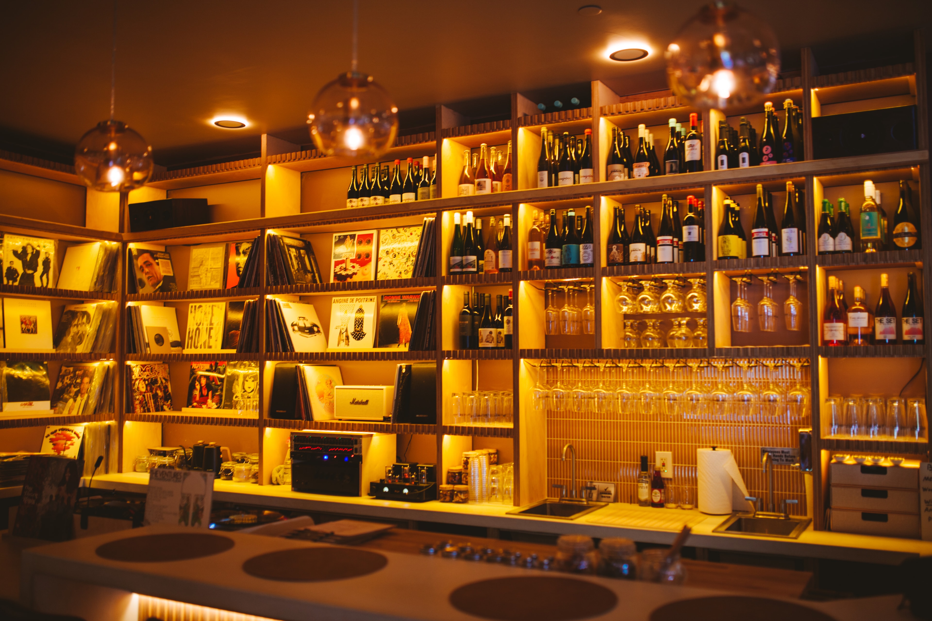 Analogue Room bar in Solvang with vinyl shelves, wine bottles, and hi-fi gear under warm pendant lights