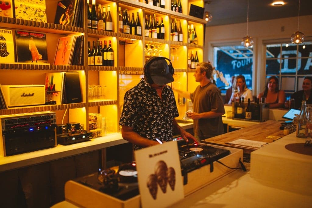 DJ spinning vinyl at the booth inside Analogue Room wine bar in Solvang